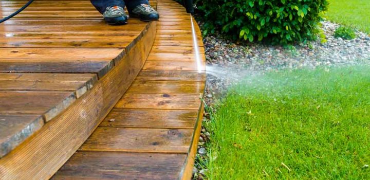 cleaning terrace with a power washer - high water pressure cleaner on wooden terrace surface